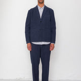 Man wearing a navy suit with a white shirt against a white background