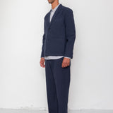 Man wearing a navy suit with a white shirt against a white background