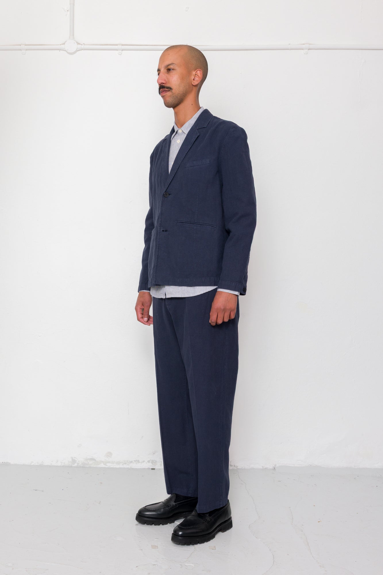 Man wearing a navy suit with a white shirt against a white background