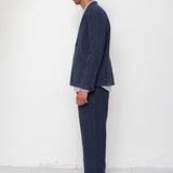 Man wearing a navy suit with a white shirt against a white background