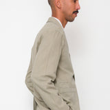 Man wearing a beige suit standing against a white background