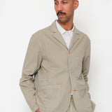 Man wearing a beige suit against a white background