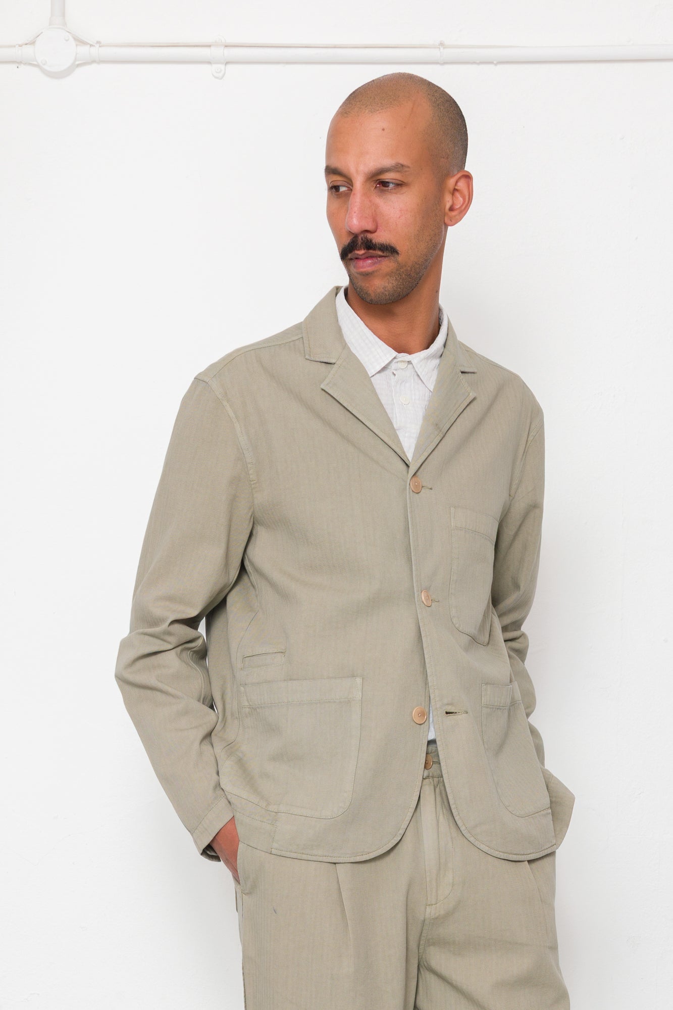 Man wearing a beige suit against a white background