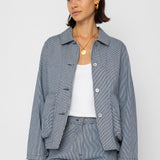 Person wearing a blue and white striped outfit with a white shirt underneath on a white background