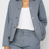 Person wearing a blue and white striped outfit with a white shirt underneath on a white background