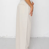 Person wearing white pants and a white top against a white background