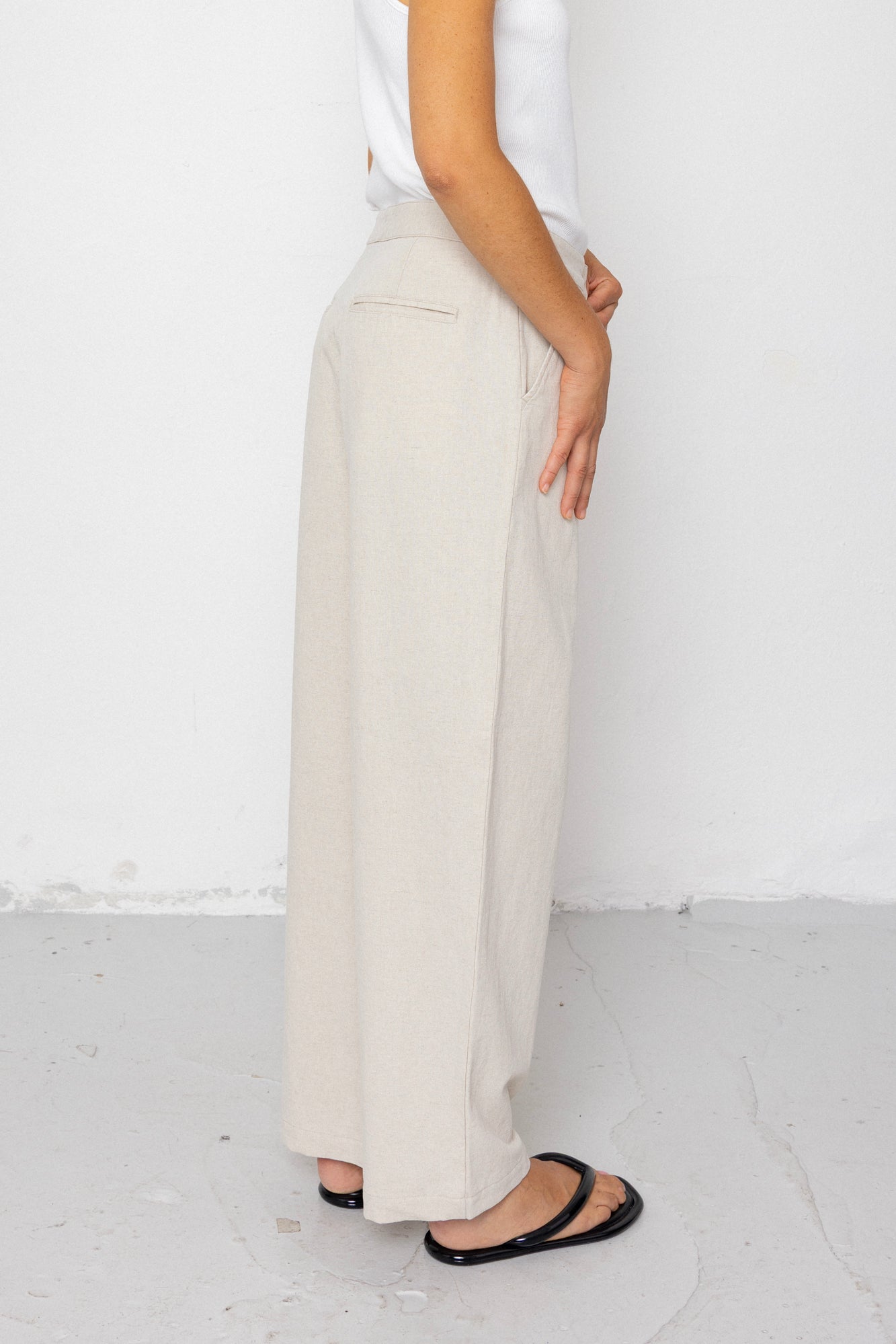 Person wearing white pants and a white top against a white background
