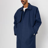 Man wearing a navy blue coat against a white background