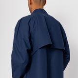 Person wearing a navy blue coat against a white background