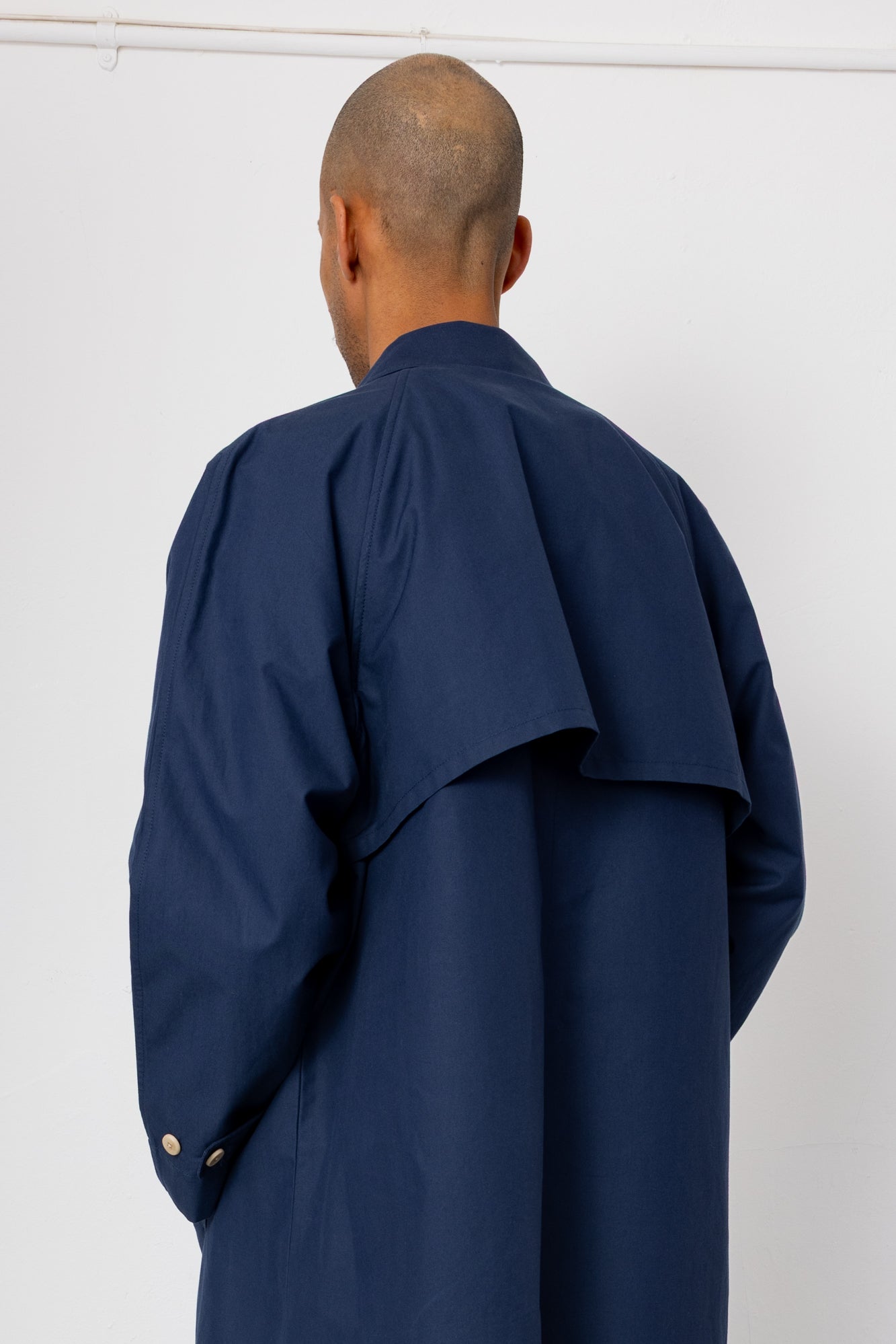 Person wearing a navy blue coat against a white background
