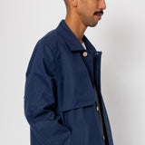 Man wearing a navy blue jacket with button details on a white background