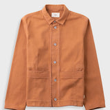 Orange cotton twill jacket laid flat against a light grey background