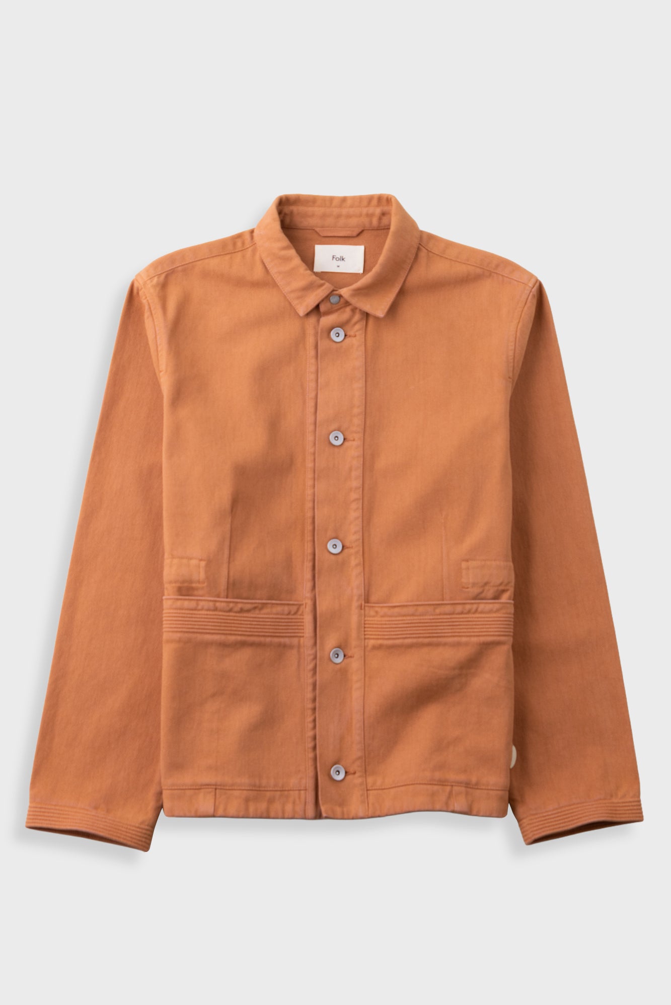 Orange cotton twill jacket laid flat against a light grey background