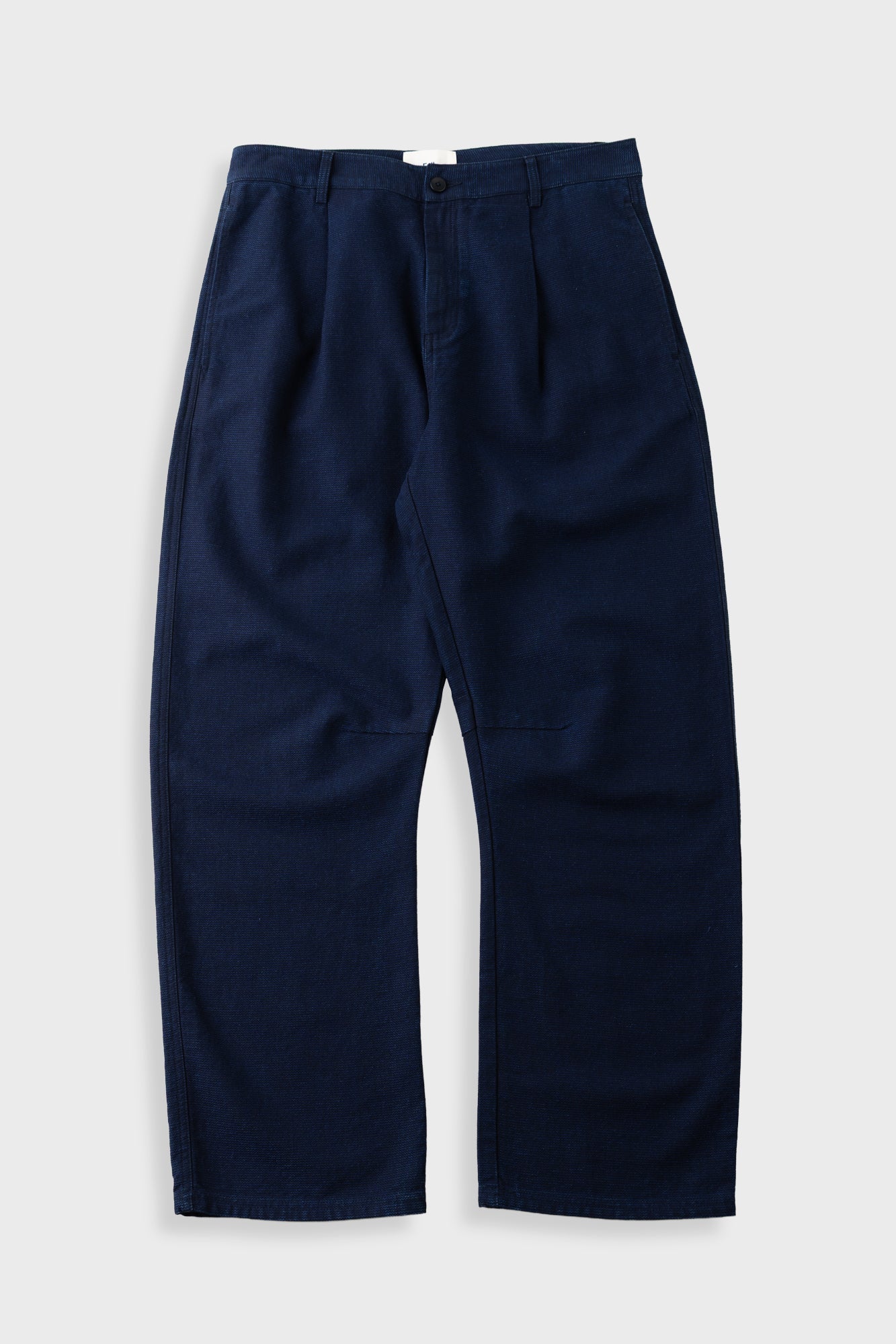 Navy barrel legged smart trousers against a light grey background