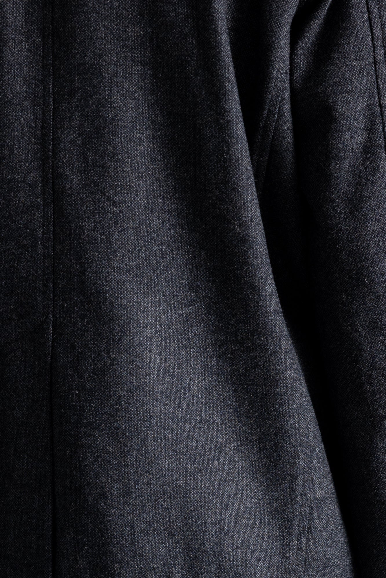 Close-up of a dark charcoal gray textured fabric, showing the weave and soft folds.
