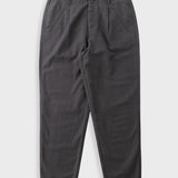 Dark charcoal gray pleated trousers laid flat against a light gray background.