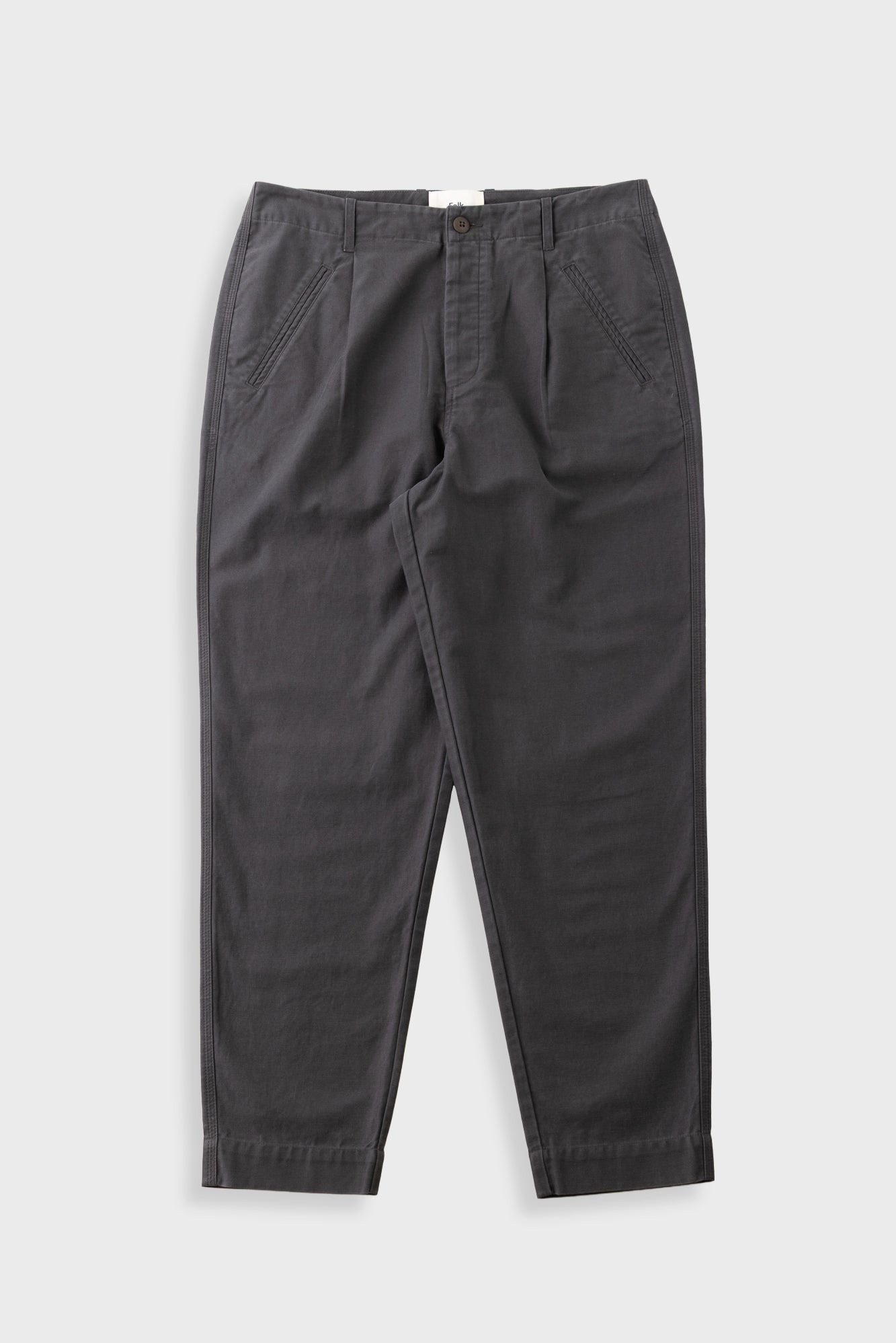 Dark charcoal gray pleated trousers laid flat against a light gray background.