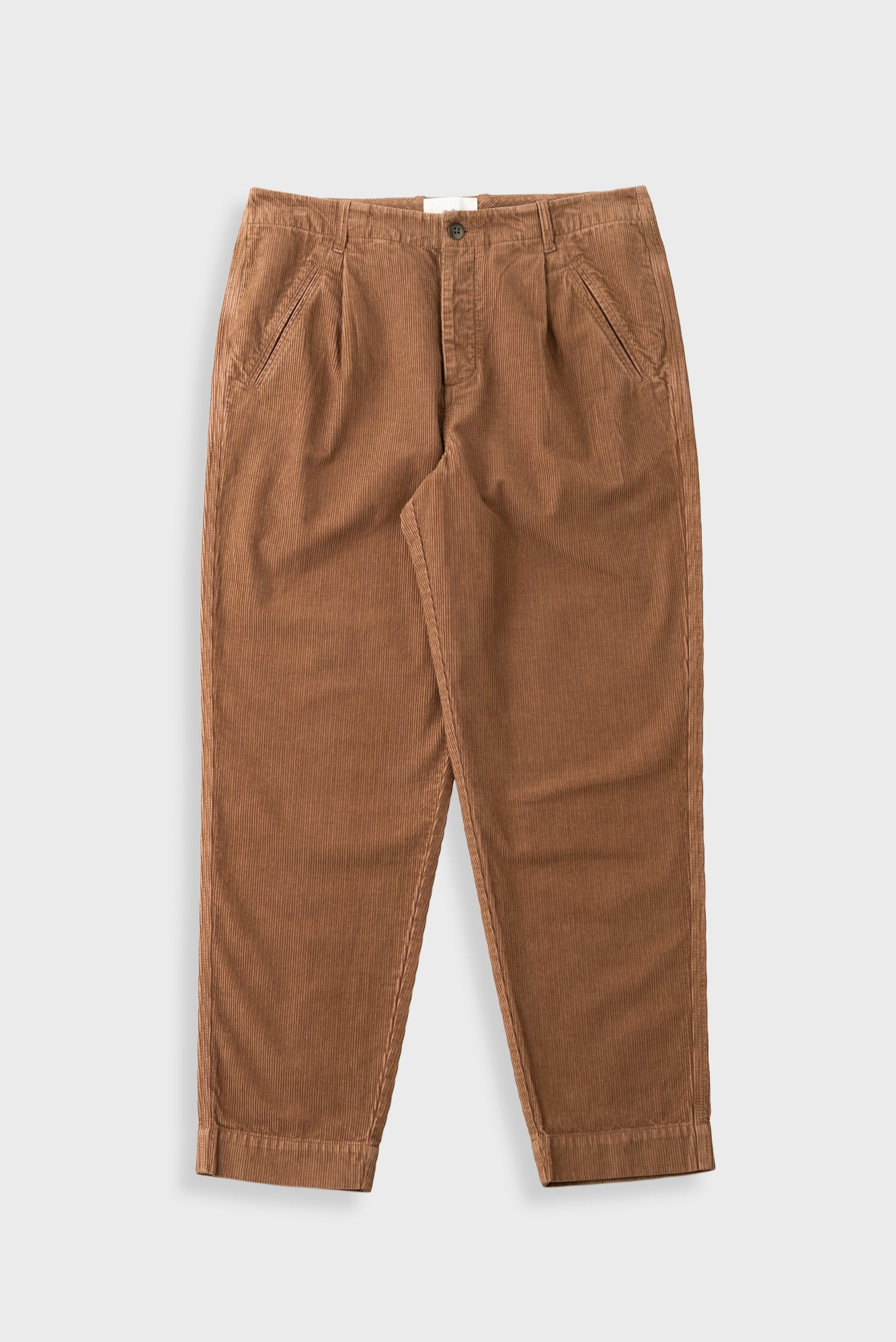 Orange brown cord trousers against a light grey background