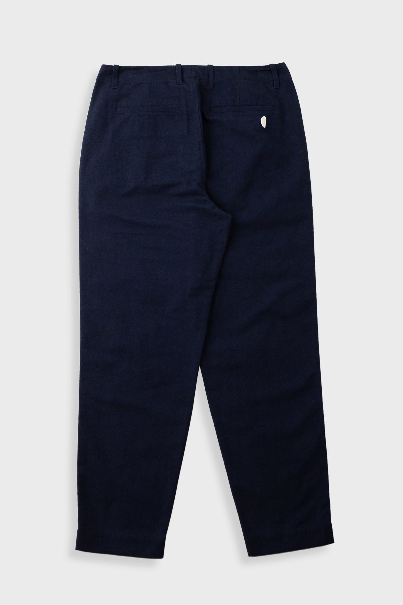 Navy pants worn by a person on a white background