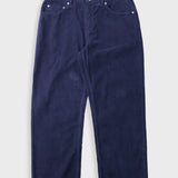 Navy cord trousers laid flat against a light grey background