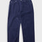 Navy cord trousers laid flat against a light grey background