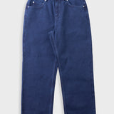 Deep blue jeans laid flat against a light grey background