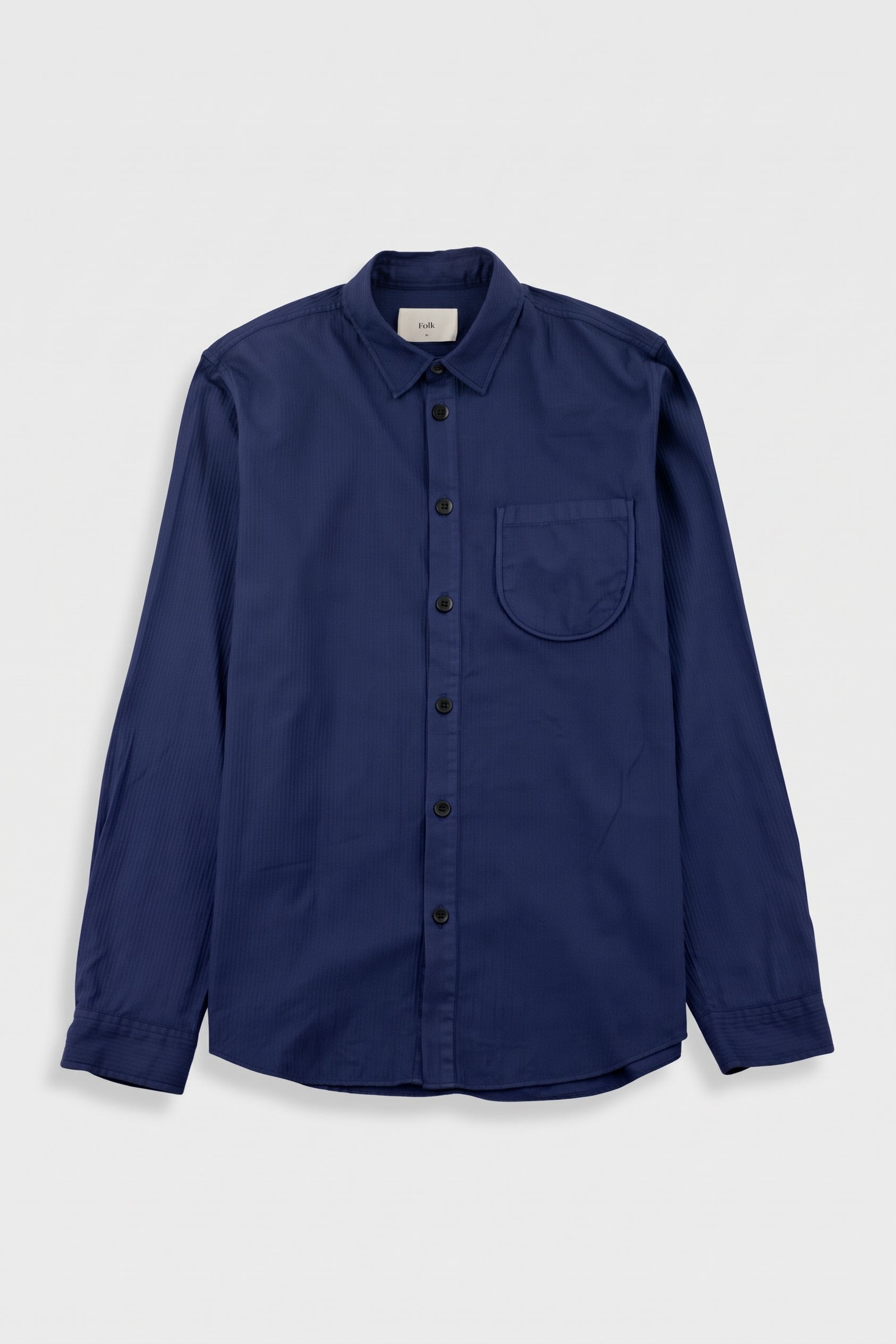 A navy blue long-sleeve button-up shirt with a single chest pocket, displayed flat against a light gray background.