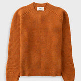 Orange knitted jumper against a light grey background