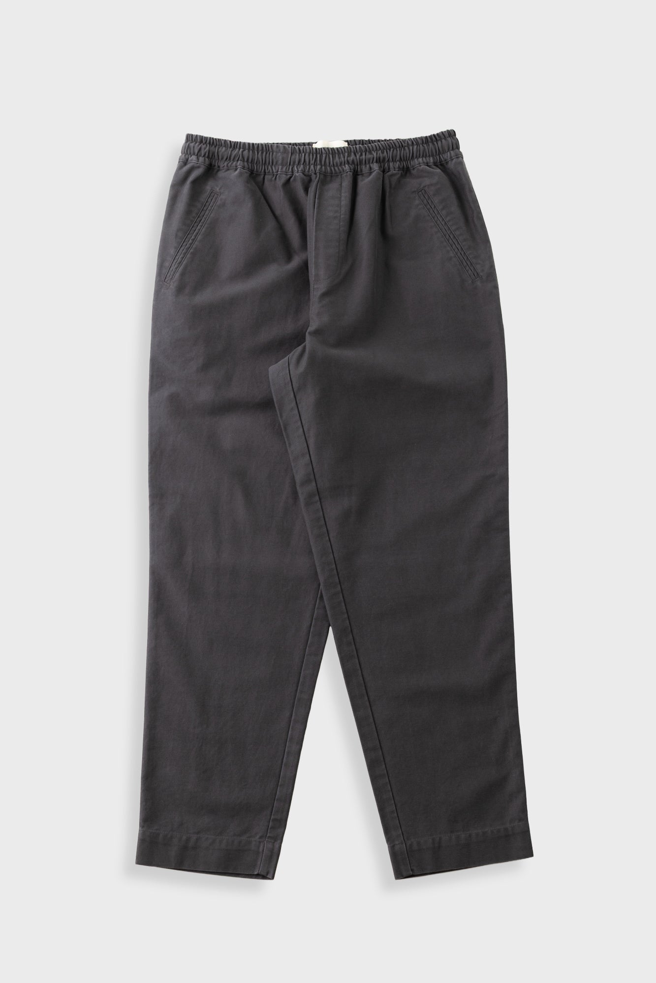 Dark charcoal gray drawstring pants with a relaxed, tapered leg, laid flat on a light gray background.