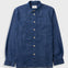 A dark blue denim long-sleeve button-up shirt with a chest pocket, laid flat against a light gray background.