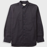 Textured brown striped shirt laid flat against a grey backdrop