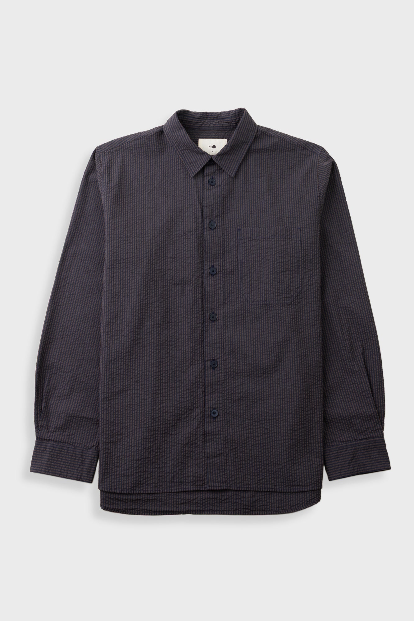 Textured brown striped shirt laid flat against a grey backdrop