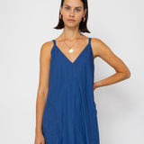 Woman wearing a blue dress against a white background