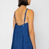 Woman wearing a blue dress with thin straps on a white background