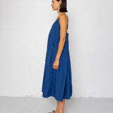 Woman wearing a blue dress standing against a white background