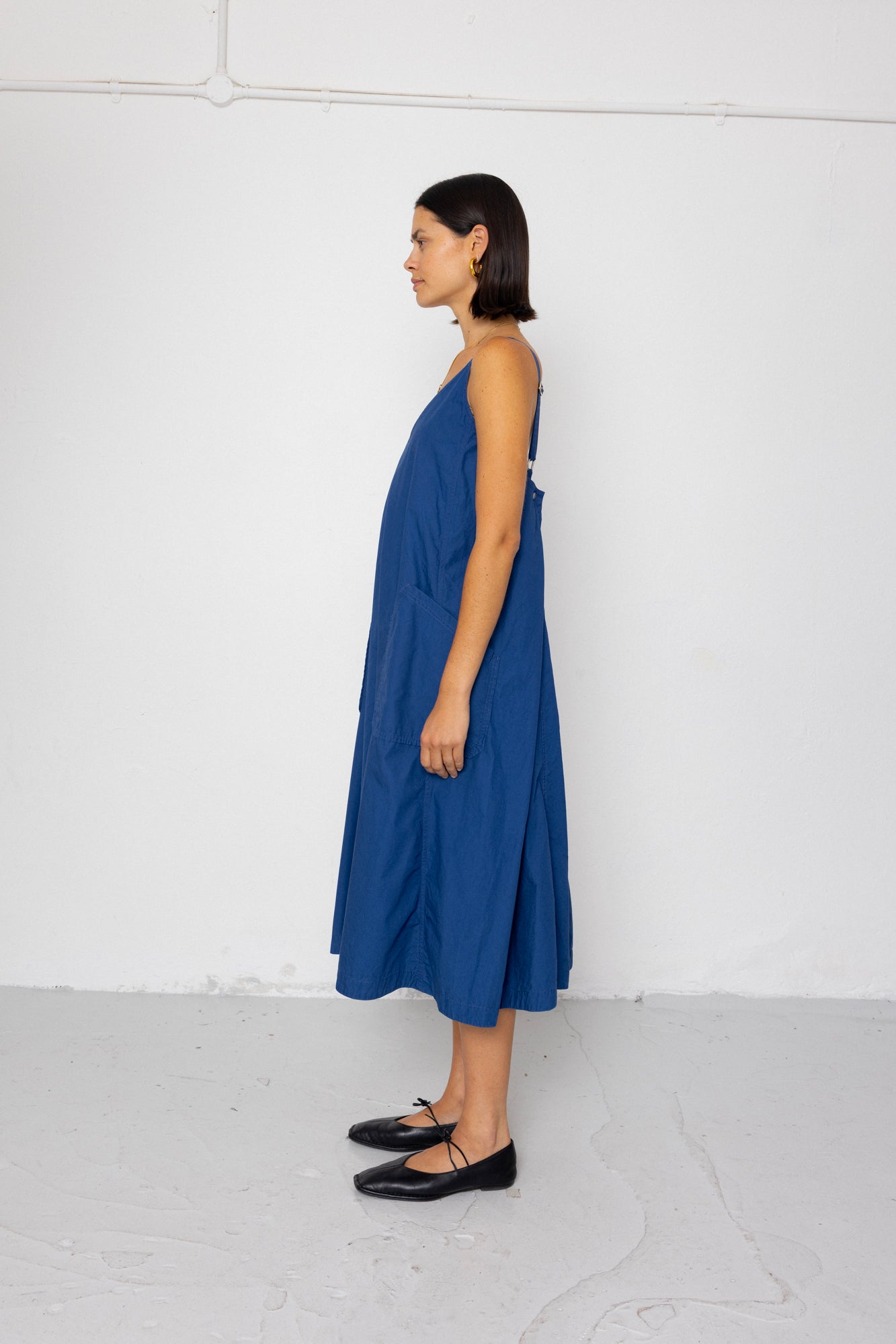 Woman wearing a blue dress standing against a white background