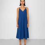 Woman wearing a blue dress standing against a white background
