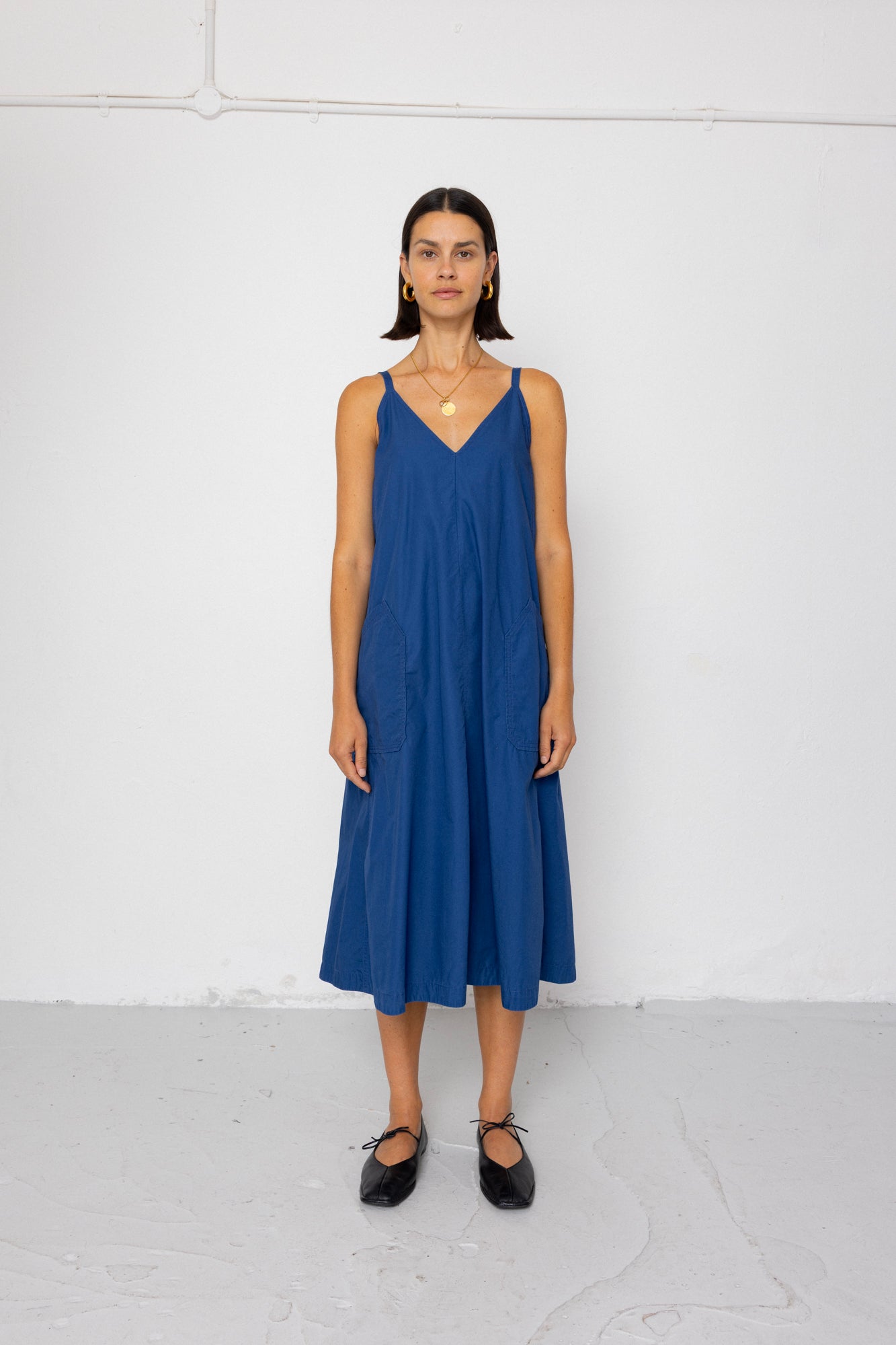 Woman wearing a blue dress standing against a white background