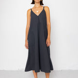 Woman wearing a black sleeveless dress against a white background