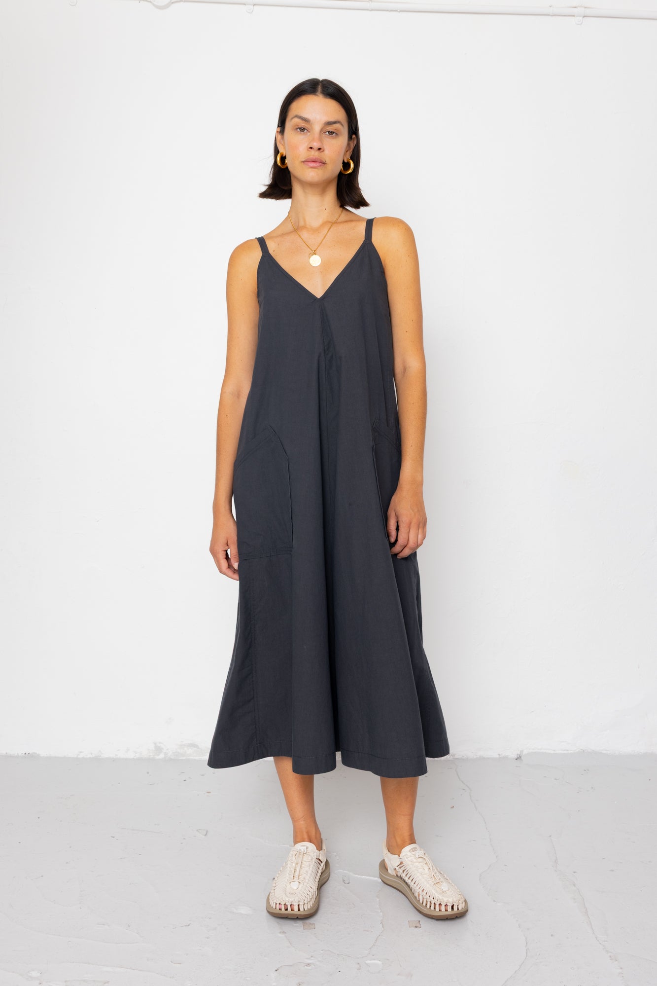 Woman wearing a black sleeveless dress against a white background