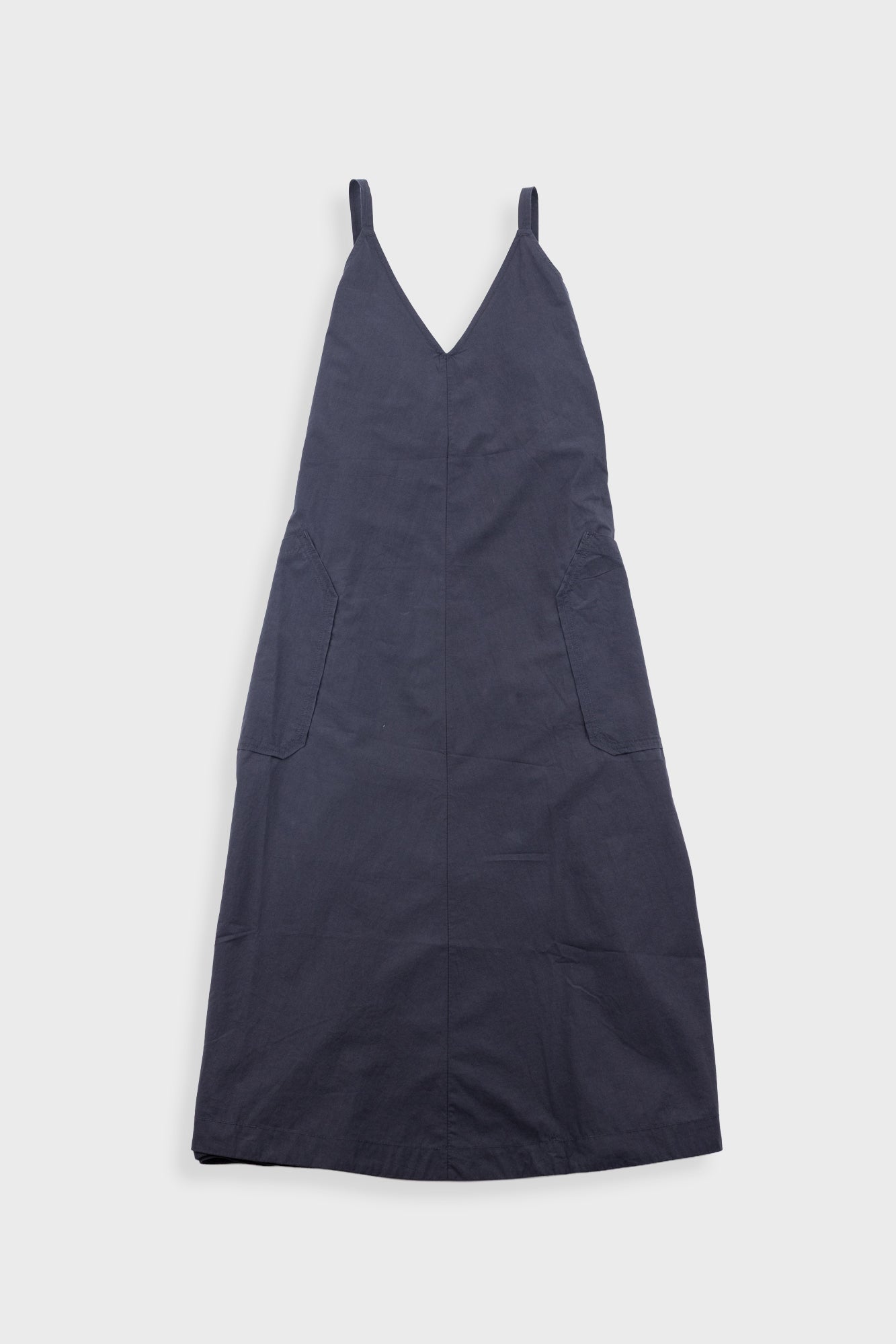 Navy blue dress with thin straps on a light gray background