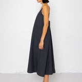 Woman wearing a dark gray dress standing against a white background