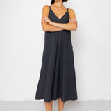 Woman wearing a black sleeveless dress with a white background