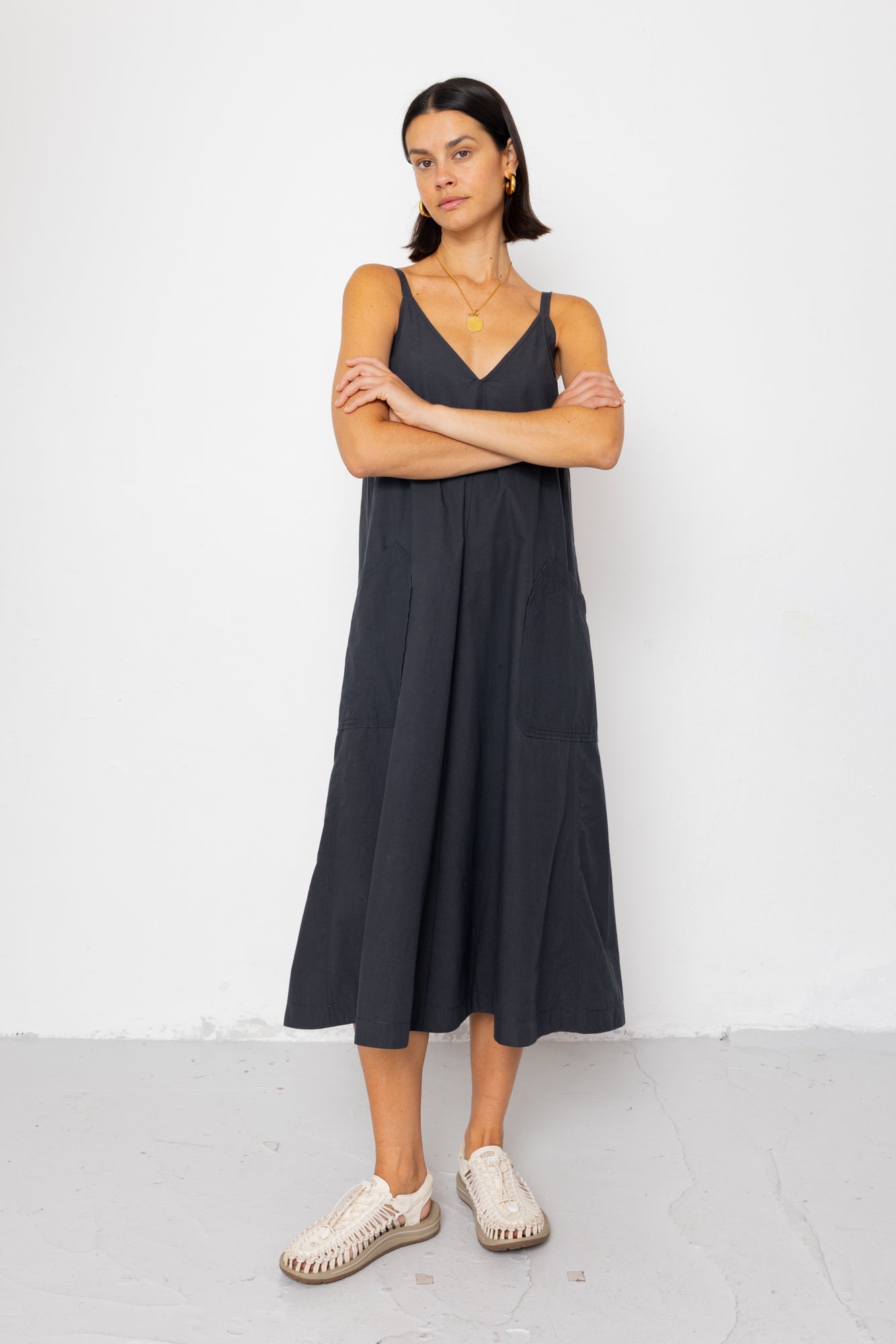 Woman wearing a black sleeveless dress with a white background