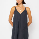 Woman wearing a black slip dress against a white background