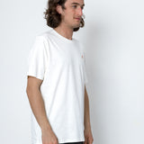 Man wearing a plain white t-shirt against a white background