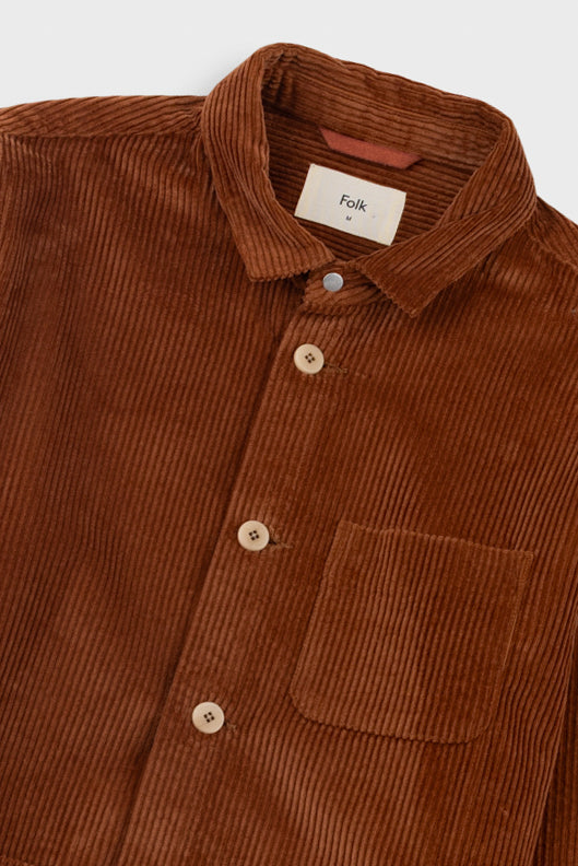 Brown corduroy shirt with a visible brand label on a white background
