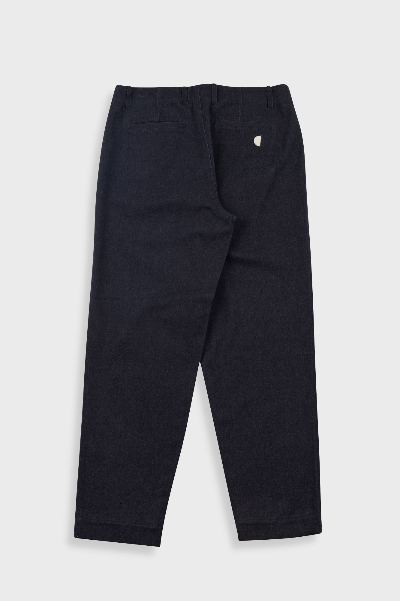 Black pants with a small white logo on a light gray background