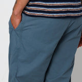 Person wearing blue pants and a striped shirt on a plain background