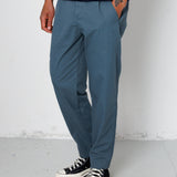 Person wearing blue pants and a striped shirt with black sneakers on a plain background